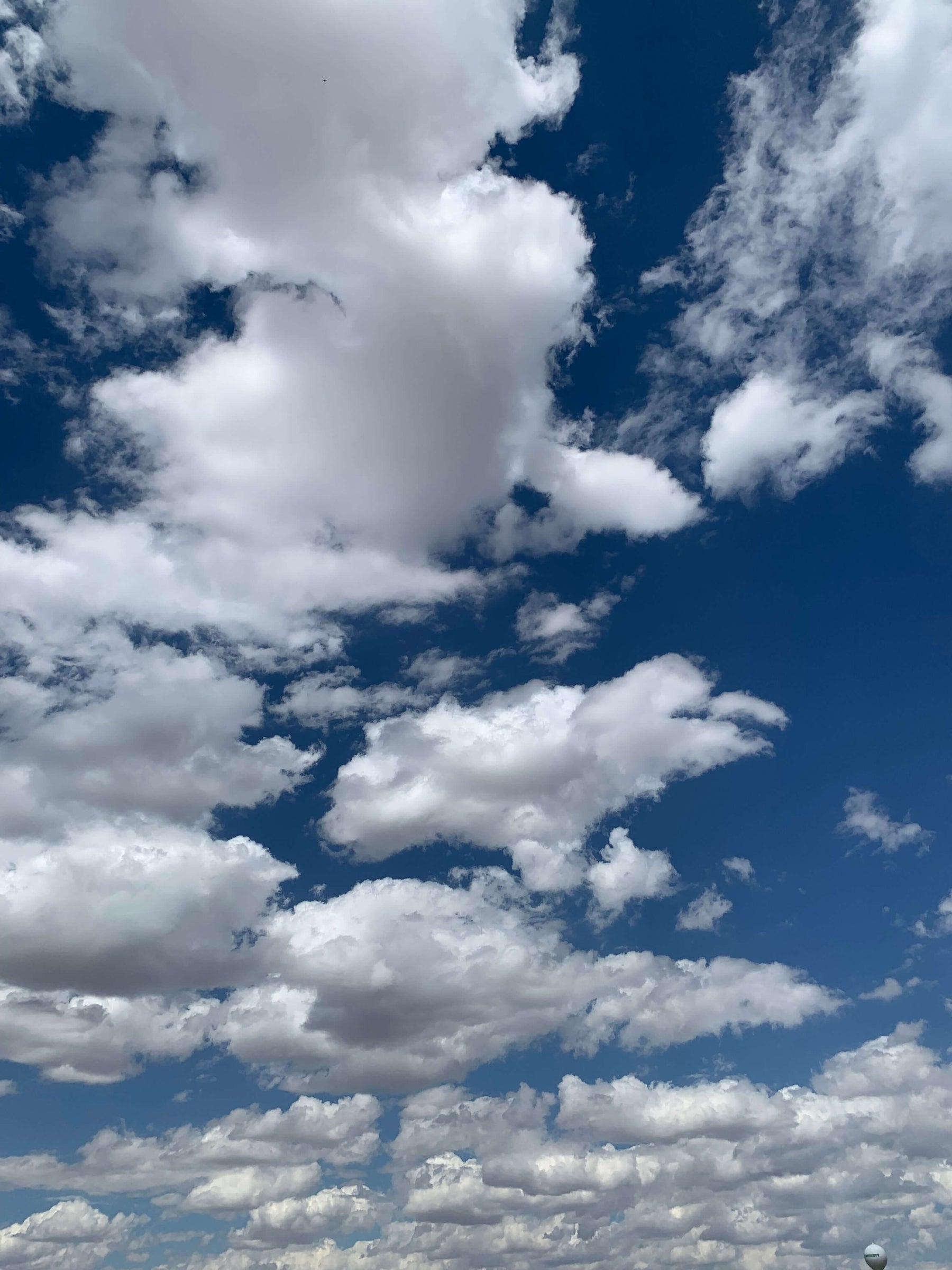 Fluffy white clouds against a deep blue sky conveying a sense of peace and spiritual wellness.