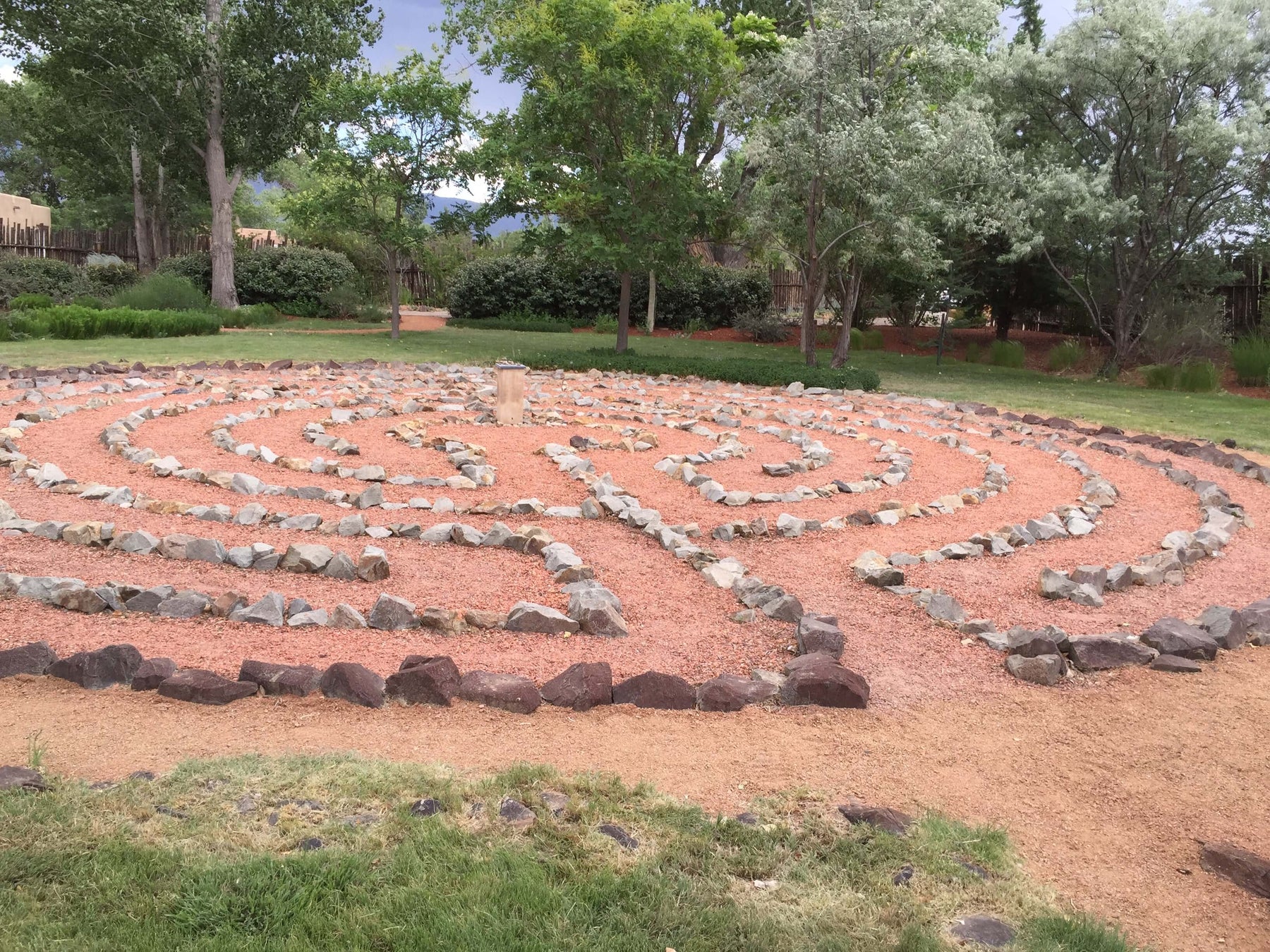 Stone labyrinth in a tranquil garden setting, symbolizing the journey of the soul and the introspective path between heart and mind.