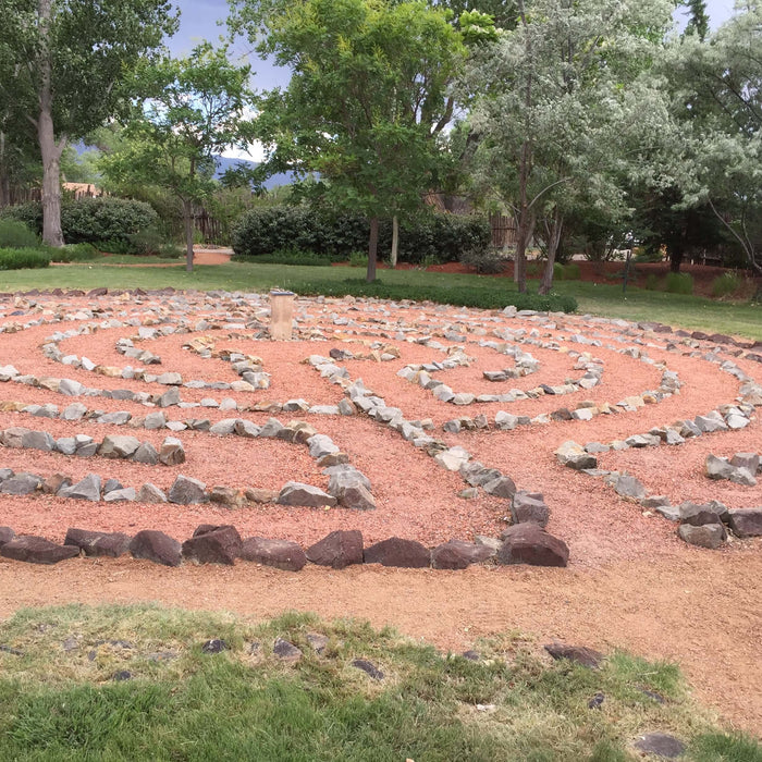 Stone labyrinth in a tranquil garden setting, symbolizing the journey of the soul and the introspective path between heart and mind.