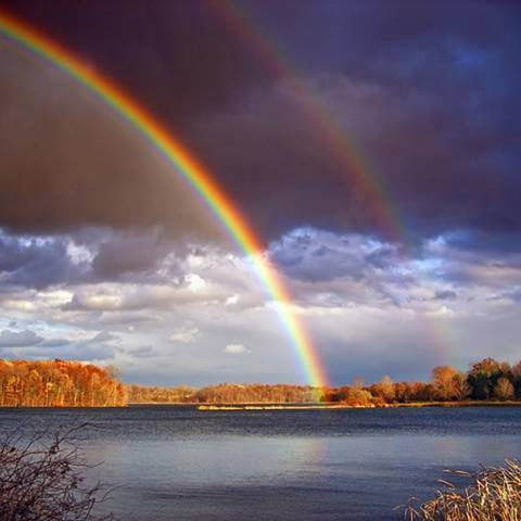 Double rainbow over a serene lake landscape, reflecting the power and beauty of nature's intuition.