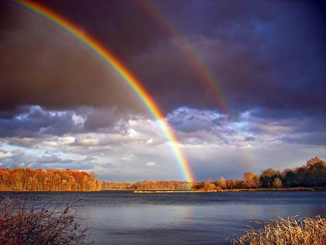 Double rainbow over a serene lake landscape, reflecting the power and beauty of nature's intuition.