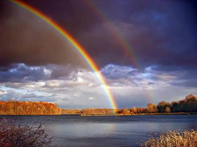 Double rainbow over a serene lake landscape, reflecting the power and beauty of nature's intuition.