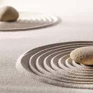 Zen garden with stones and raked sand, symbolizing calmness and a mindset geared towards wealth and prosperity.