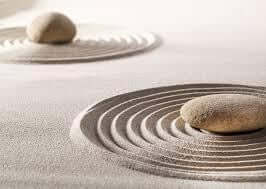 Zen garden with stones and raked sand, symbolizing calmness and a mindset geared towards wealth and prosperity.