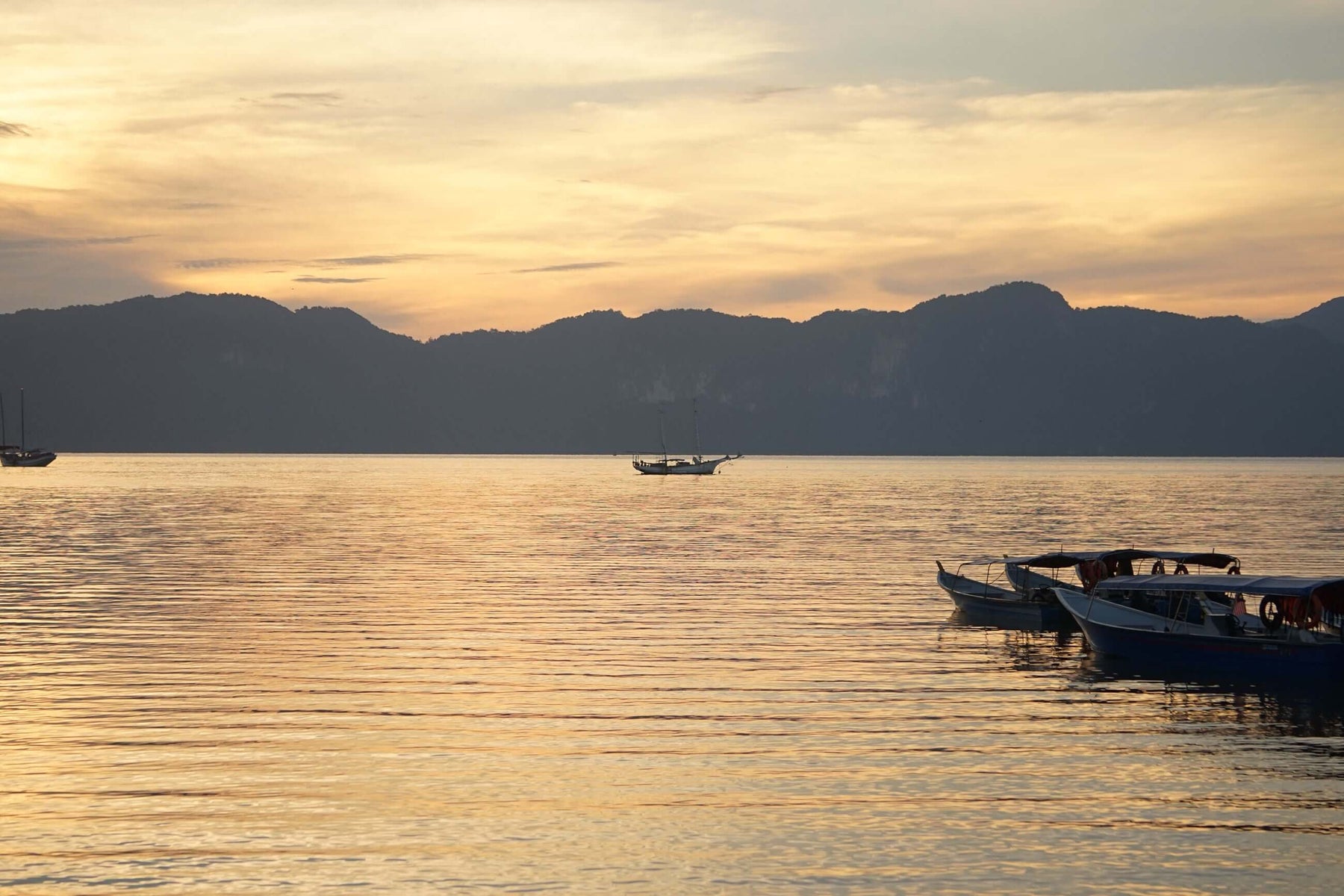 Serene coastal Mexican village at sunset with boats on calm water, reflecting the parable of the Mexican fisherman and the businessman.