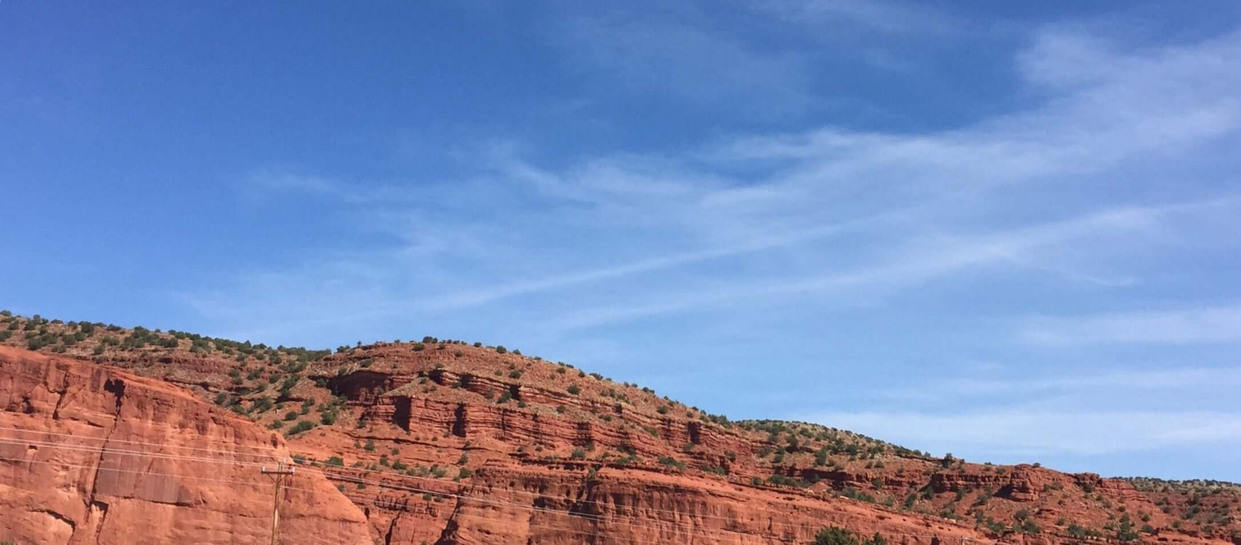 Red rock formations under a clear blue sky in scenic desert landscape.