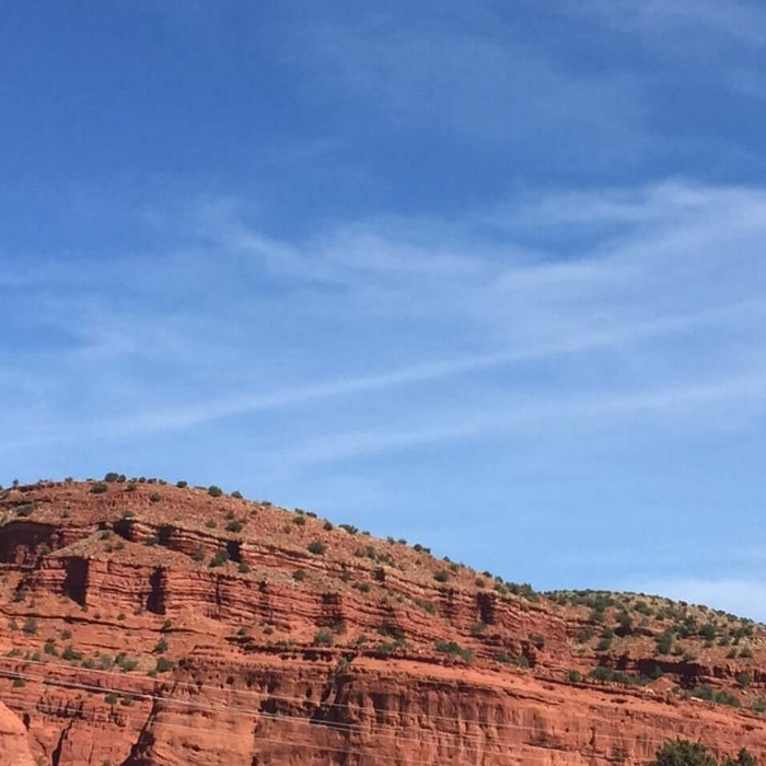 Red rock formations under a clear blue sky in scenic desert landscape.