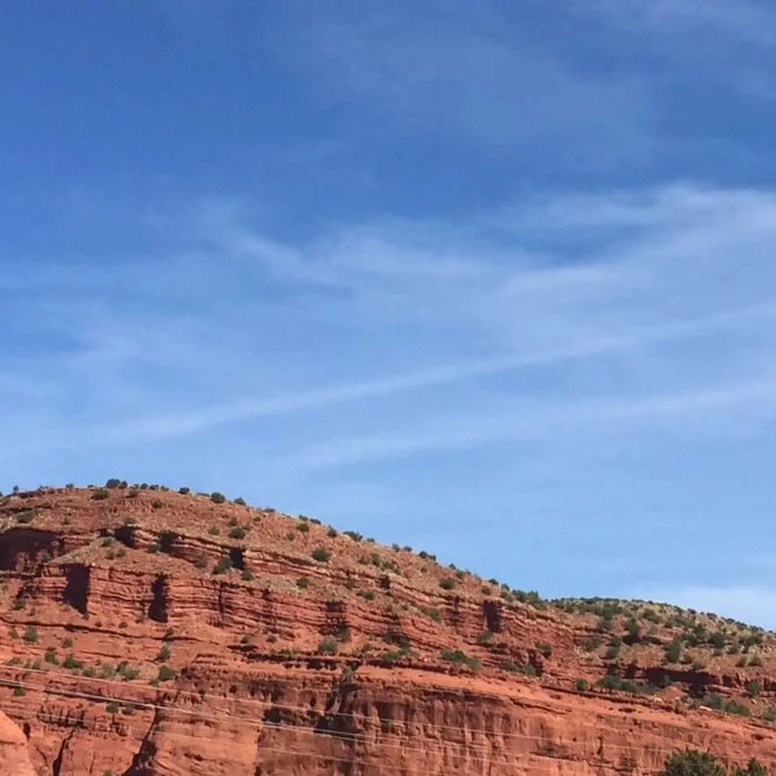 Red rock formations under a clear blue sky in scenic desert landscape.