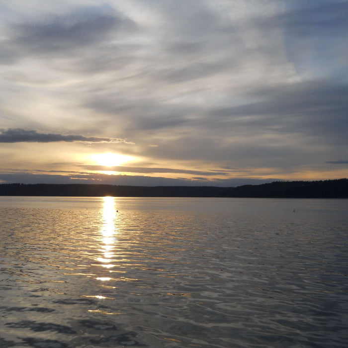 Serene sunset over a calm lake, symbolizing inner peace and personal development in pursuit of happiness.